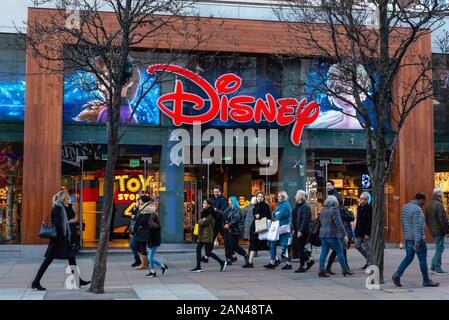 London shoppers Oxford Street London retail people walking past the colourful shop front of Disney Toy Store in Oxford Street, London, UK Stock Photo