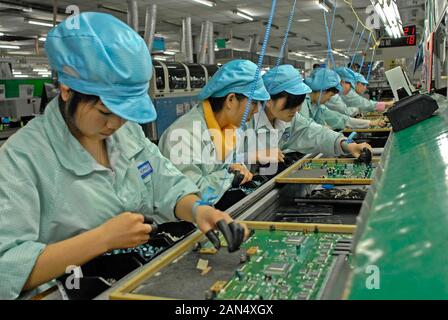 --FILE--Chinese migrant workers labor at an electronics factory in Dongguan city, south Chinas Guangdong province, 9 March 2012.  Zhan Youbing, a form Stock Photo