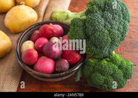 Radish, broccoli and potatoes close up on a wooden rustic background Stock Photo