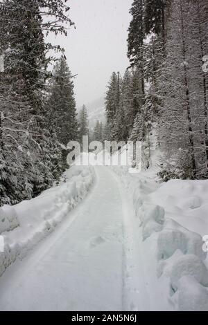 The snow-covered road after a winter front, coming down from Eagle View, in northwest Sanders County, Montana. Stock Photo