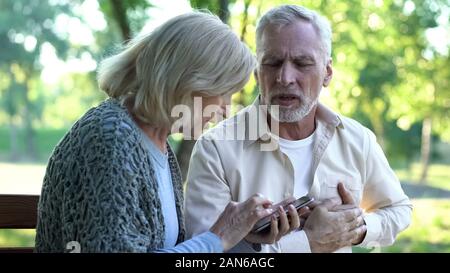 Old male having chest pain, heart attack, worried wife calling 911, emergency Stock Photo