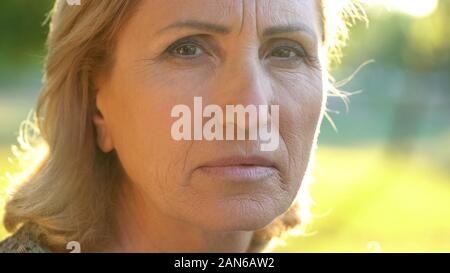 Old woman sadly looking at camera, fear of loneliness, hopelessness and poverty Stock Photo