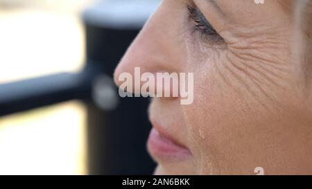 Aged woman crying, remembering departed native person, pain of loss, close-up Stock Photo