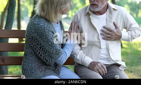 Senior man having heart attack during walk with wife, cardio problems healthcare Stock Photo