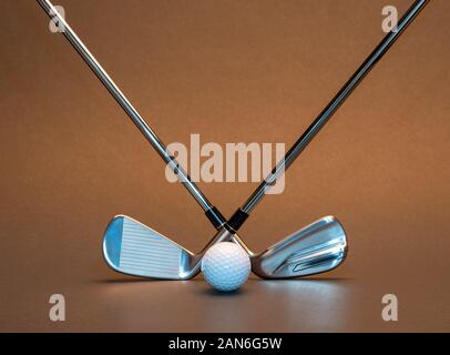 Two crossed golf clubs and golf ball in the middle Stock Photo