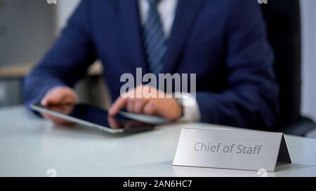Young chief of staff working on tablet pc in office, solving corporate problems Stock Photo