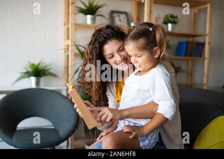 Beautiful woman and kid girl playing educational toys and having fun Stock Photo