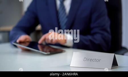 Serious company director using tablet pc on workplace, checking important files Stock Photo