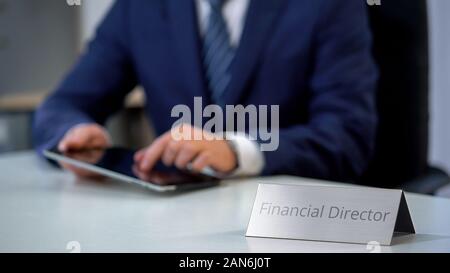 Serious financial director of corporation working on tablet pc, budget planning Stock Photo