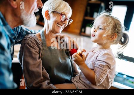 Grandparents playing and having fun with their granddaughter Stock Photo