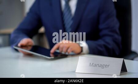 Young business manager working on project online, using tablet computer Stock Photo