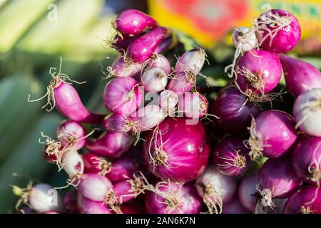 A bunch of red onions (close up). On sale at a farmers market in a small town called Praid (Romania). Fresh, ripe vegetable. Healthy, organic food. Stock Photo