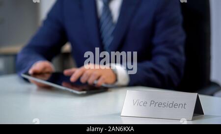 Busy vice president working on tablet pc in office, scrolling and zooming files Stock Photo