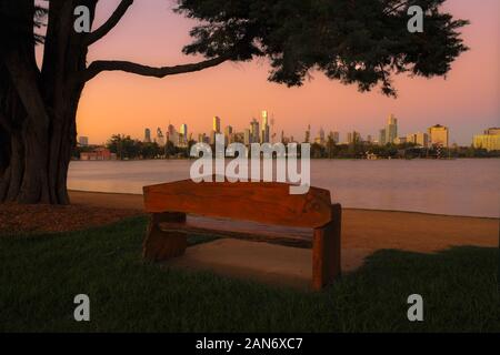 A view of Melbourne at sunrise looking across Albert Park lake.