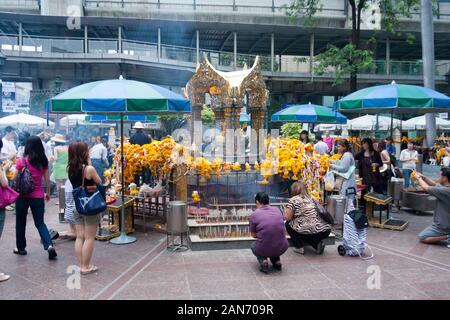 Bangkok, Thailand - April 21st 2011: Buddhist followers at the Erawan shrine. The shrine is one of the most revered in the city. Stock Photo