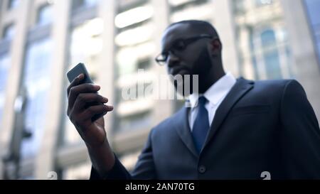 Concentrated businessman using smartphone for work, trading online, internet Stock Photo
