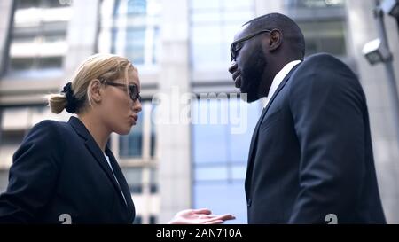 Female boss scolding subordinate, employee justifying himself, business ethics Stock Photo
