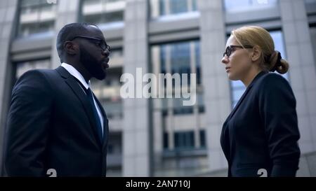 Male boss scolding subordinate, employee justifying herself, business ethics Stock Photo