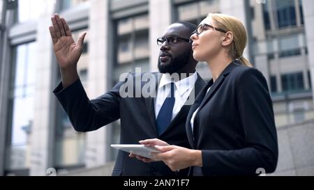 Business team of engineers discussing architectural design, using digital tablet Stock Photo