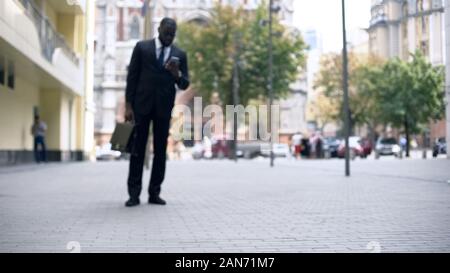 Businessman walking to work and using smartphone, busy lifestyle in big city Stock Photo