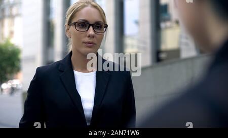 Young female boss scolding employee, angry about failed project, business ethics Stock Photo