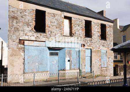 CONWY, UK - February 26, 2012. Abandoned local shop on a high street in Wales, with boarded up windows Stock Photo