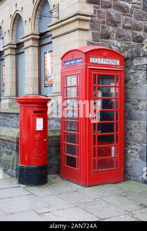 CONWY, UK - February 26, 2012. Royal Mail post box and BT telephone box outside an old building in Wales Stock Photo