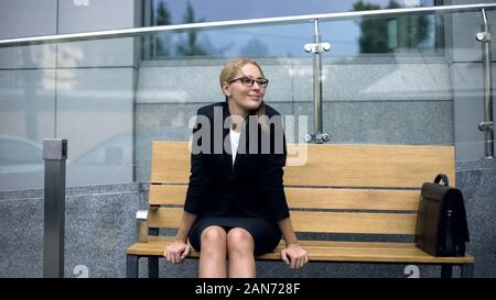 Female office employee sitting on bench, worrying bout troubles at work, stress Stock Photo
