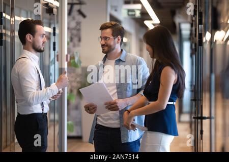 Multiethnic employees talk meeting in modern office hallway Stock Photo