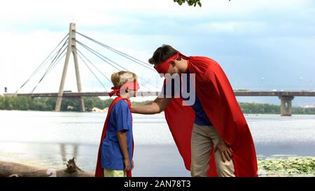 Superman inspires son-superhero to win, paternal support, advice for real man Stock Photo