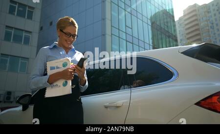 Happy business woman looking on phone, reading message, good news from investors Stock Photo