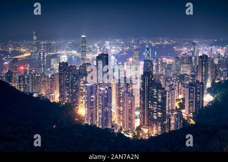 Hong Kong city skyline at night. Cityscape with skyscrapers against traffic in Victoria Harbour. Stock Photo
