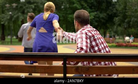Teen walking away after quarrel, mother trying to stop him, teenage problems Stock Photo