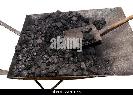 Wheelbarrow loaded with coal on which the shovel lies, isolated on a white background with a clipping path. Stock Photo