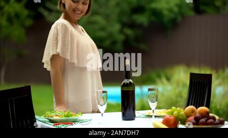 Perfect housewife sets table with healthy food, preparation for celebration Stock Photo