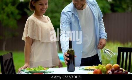 Husband and wife setting table for romantic lunch, having nice time together Stock Photo