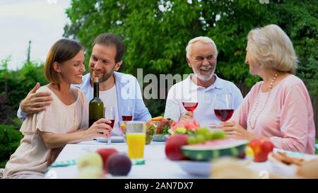 Parents and grown up children having lunch in backyard of villa, two generations Stock Photo