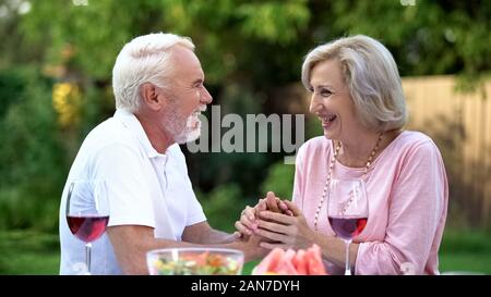 Laughing senior couple having fun during dinner, positive emotions, happiness Stock Photo