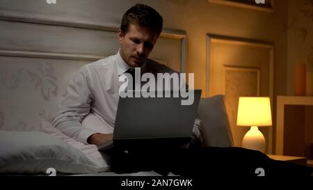 Young creative director working on project late at night in hotel, business trip Stock Photo