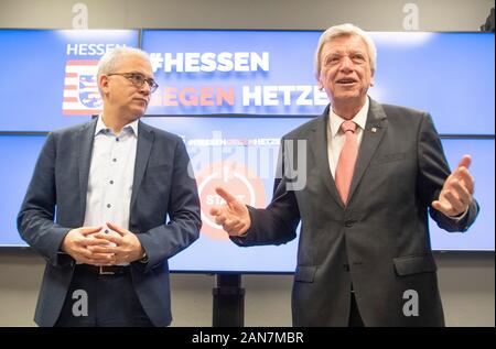 Wiesbaden, Germany. 16th Jan, 2020. Prime Minister Volker Bouffier (CDU, r) and Minister of Economics Tarek Al-Wazir (Greens) stand in front of monitors with the inscription 'Hessen gegen Hetze' (Hesse against agitation) during the official commissioning of the central reporting office 'Hessen 3C'. In future, Internet users will be able to report hate comments in social media via the platform. Credit: Boris Roessler/dpa/Alamy Live News Stock Photo