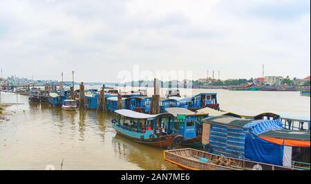 Tour boats moored on the pier on the Mekong River near My Tho, Vietnam. Stock Photo