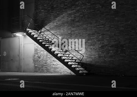 illuminated metal stair at night, simple stairway at night, black and white photo Stock Photo