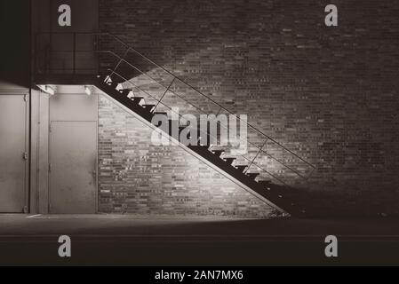 illuminated metal stair at night, simple stairway at night, black and white photo Stock Photo