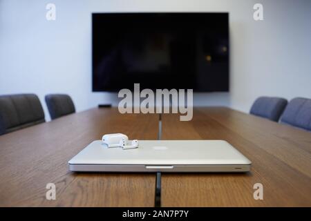 MacBook Pro with Apple EarPods in a board room location Stock Photo