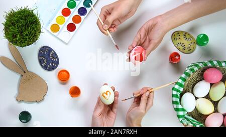 Women decorating eggs, traditional Easter activities for fun, happy holidays Stock Photo