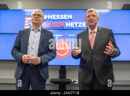 Wiesbaden, Germany. 16th Jan, 2020. Prime Minister Volker Bouffier (CDU, r) and Minister of Economics Tarek Al-Wazir (Greens) stand in front of monitors with the inscription 'Hessen gegen Hetze' (Hesse against agitation) during the official commissioning of the central reporting office 'Hessen 3C'. In future, Internet users will be able to report hate comments in social media via the platform. Credit: Boris Roessler/dpa/Alamy Live News Stock Photo