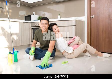 Housewife and her husband cleaning home and having fun together. Housekeeping, home cleaning and cleaning service concept Stock Photo