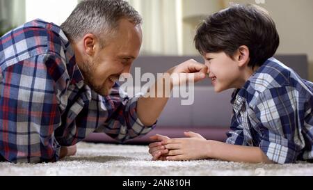 Male family playing on the floor at home, having fun together, weekend leisure Stock Photo