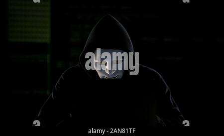 Hacker in mask breaking government servers, cyberterrorism, internet security Stock Photo