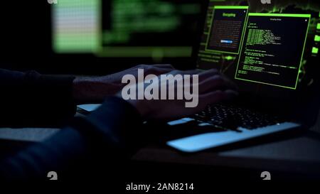 Cybercriminal creating malicious software, typing on laptop keypad, closeup Stock Photo